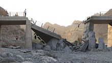 People stand on a bridge destroyed after a strike in Hormozgan province, southern Iran, on Saturday, July 18, 2026.