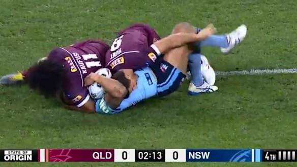 Kaufusi continues the tackle and presses Vaughan's head into the turf.