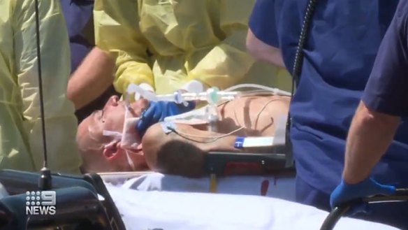 A 30-year-old man is taken to hospital on a stretcher after he was shot in a confrontation with police at The Entrance.