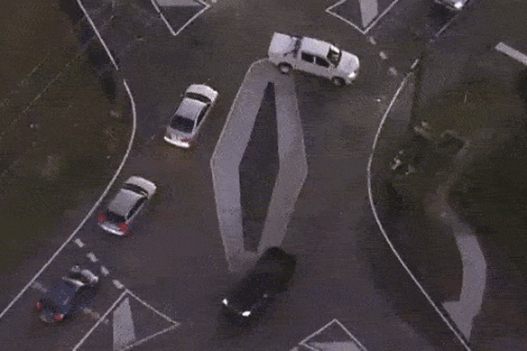 Aerial footage shows a ute doing a three-point turn to get around the diamond, while two other cars cut directly across the roundabout.