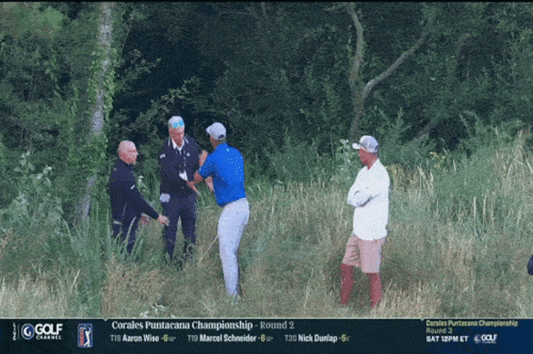 Bryson DeChambeau with rules officials on Friday.