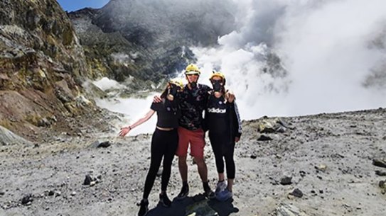 Krystal, Paul and Stephanie Browitt on the edge of the crater lake six minutes before the volcano eruption on New Zealand’s White Island.