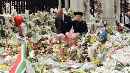 King Charles and Queen Consort Camilla look at flowers outside Buckingham Palace just as his parents did upon the death of Diana. 