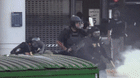 A protester throws a rock and federal agents use tear gas after immigration raids in the Paramount area of Los Angeles.