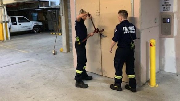 Firefighters use bolt cutters during an inspection of the Auburn apartment tower.