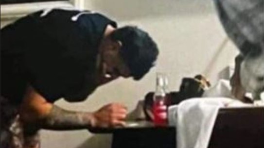 Latrell Mitchell appearing to lean over a table with a white substance on it. There is no suggestion the substance is an illicit drug.