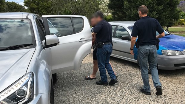 A man is arrested by AFP officers in Caboolture, north of Brisbane, on Tuesday.
