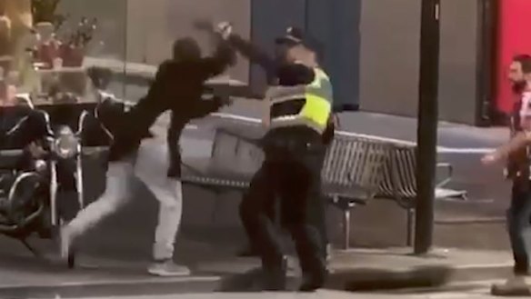 Police officers confront Hassan Khalif Shire Ali on Bourke Street. 