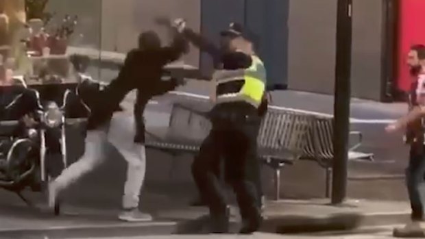 Police officers confront Hassan Khalif Shire Ali on Bourke Street. 