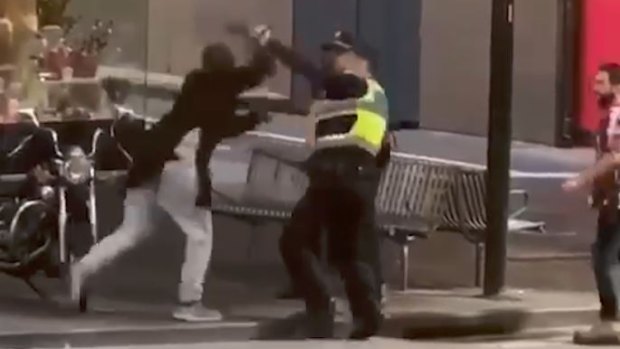 Police officers confront Hassan Khalif Shire Ali on Bourke Street. 