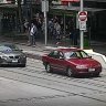 The offender on Swanston Street with police a metre behind him.