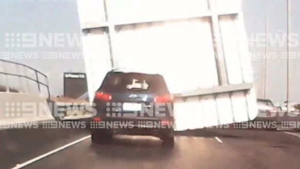 Sign fall: Tullamarine Freeway sign falls and crushes car, injuring woman