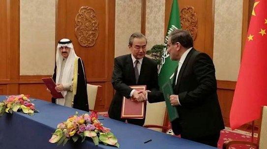 Secretary of Iran’s Supreme National Security Council, Ali Shamkhani, right, shakes hands with China’s most senior diplomat Wang Yi, as Saudi Arabia’s National Security Adviser Musaad bin Mohammed al-Aiban looks on.