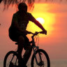 A generic photo of a cyclist riding along a bike path at sunset. Photo Glenn Campbell