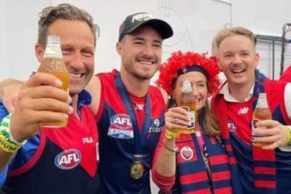 Melburnians Hayden Burbank, left, and Mark Babbage, right, pictured with Demons player Alex Neal-Bullen, were questioned by police after allegedly breaking restrictions to travel to the grand final in Perth.