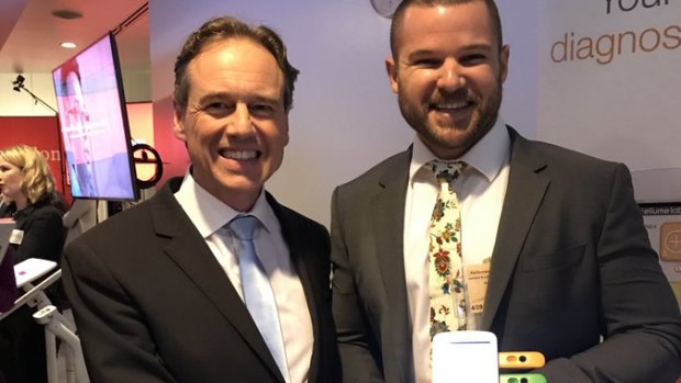 Health Minister Greg Hunt poses with Jim Darrouzet and an Ellume self-testing kit in September 2017.
