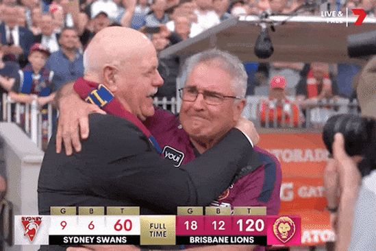 AFL Legend Leigh Matthews hugs premiership coach Chris Fagan.