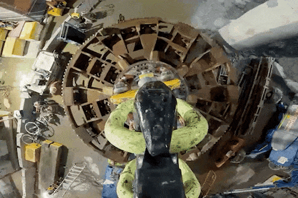 A cutterhead from the tunnel boring machine is lifted out of the giant cavern beneath Hunter Street.