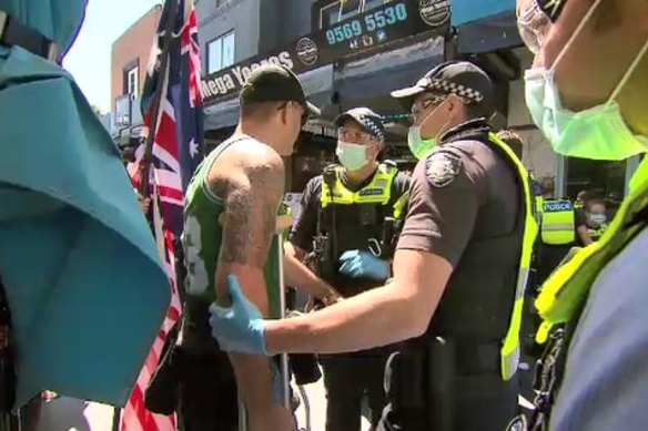 Anti-lockdown protestors and police face off at Eaton Mall in Oakleigh on Monday.