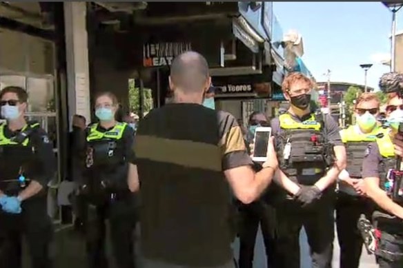 Police in masks respond to an anti-lockdown protest at Eaton Mall on Monday.