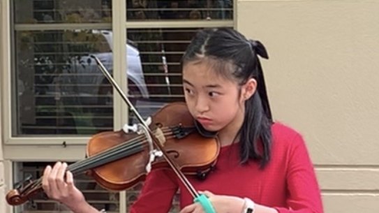 Tiana Ekpanyaskun playing her adapted violin.