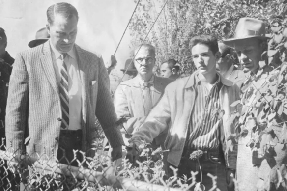 William Leslie Arnold (centre) shows detectives where he buried his parents in their backyard in 1958.
