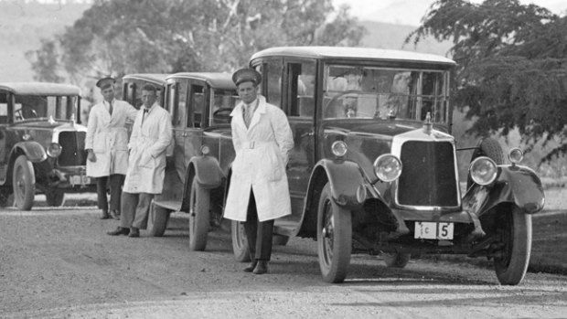 White-coated Commonwealth drivers and their Armstrong Siddeley cars gather at the Governor-General's residence in Yarralumla, circa 1930.