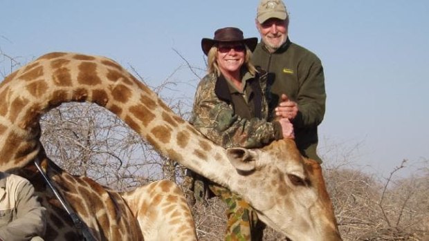 Eric John Newman and his wife Lesley Ann Newman pose with the carcass of a giraffe. 