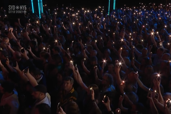 Concertgoers hold up torch lights during the minute of silence.