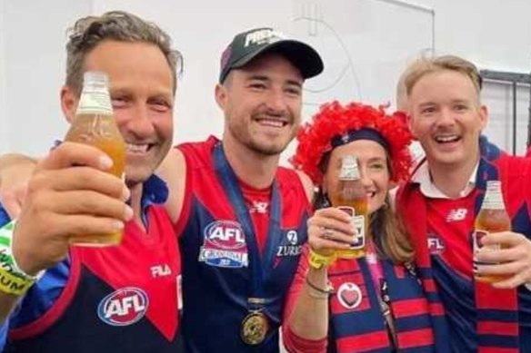 Melburnians Hayden Burbank, left, and Mark Babbage, right, pictured with Demons player Alex Neal-Bullen, were questioned by police after allegedly breaking restrictions to travel to the grand final in Perth.