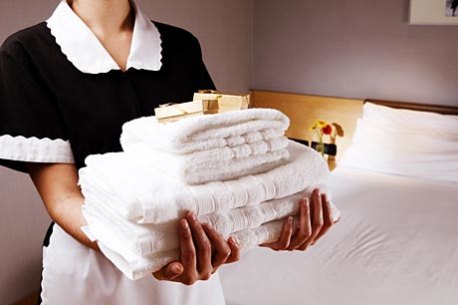 Hotel maid with towels.