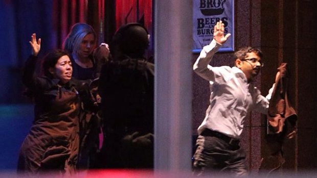 Hostages are assisted from the Lindt cafe siege in Martin Place in Sydney, December 16, 2014.