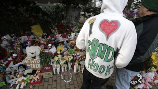 A Sandy Hook resident wears a handmade sweatshirt in support of his town while looking at a memorial to the Newtown shooting victims in the Sandy Hook village of Newtown, Connecticut.