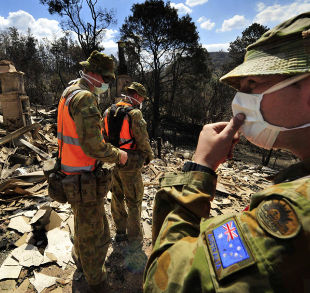 Members of the army's Victorian search task group inspect properties and look for bodies in Flowerdale, three days after Black Saturday.
