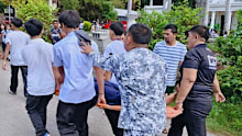 An injured student is carried by Coast Guard personnel and other students as they provide assistance for earthquake victims at a school in Sta Cruz in the Davao del Sur province.