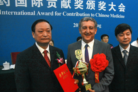 Professor Alan Bensoussan receives the International Award for Contribution to Chinese Medicine at Beijing's Great Hall of the People in 2013, flanked by Chinese Vice-Minister of Health Wang Guoqiang (left). 