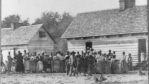 Large group of slaves standing in front of buildings on Smith's Plantation, Beaufort, South Carolina.