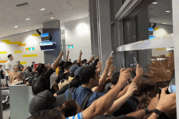 Para pendukung menggunakan senter ponsel mereka untuk memberi sinyal kepada tim di landasan.