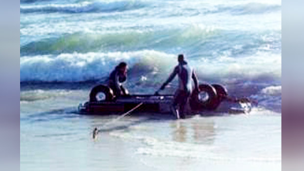 Ms Cutler's car is taken out of the water by two police divers.