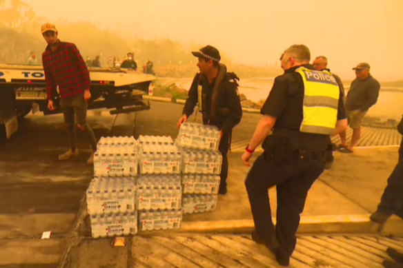 Bottles of water are unloaded at Mallacoota on Thursday.