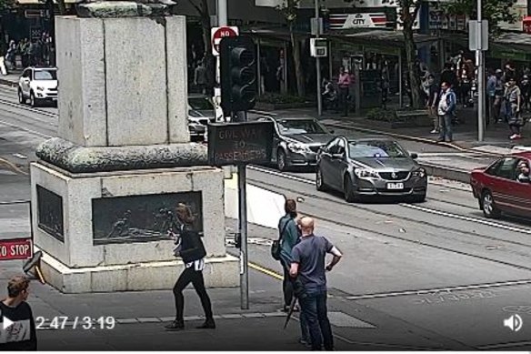 The offender on Swanston Street with police a metre behind him.