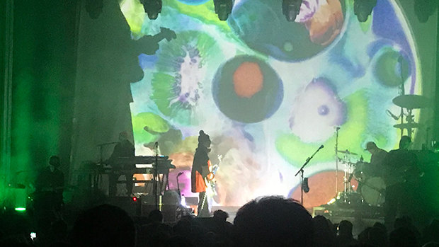 Psychedelic swirls tower over the band in their Australian tour.