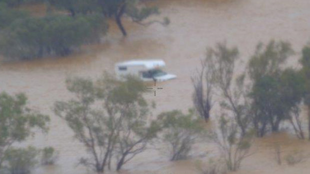 The tourists were stranded by floods when a grazier came to the rescue in his helicopter.