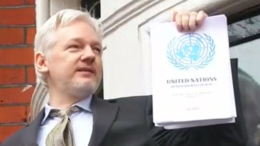 Julian Assange brandishes a 2016 UN report that found he was being detained unlawfully.
