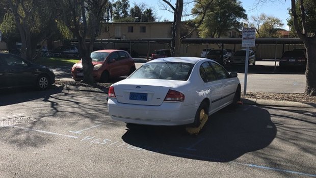 A Perth real estate agent and a prospective buyer had their cars' wheels clamped – despite parking in the designated visitors' bays. 
