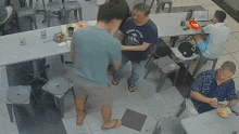 Khoon is shoved into tables and chairs.