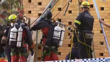 Police divers and fire service rescue personnel retrieving Guise’s body from the Wynnum sewage tank.