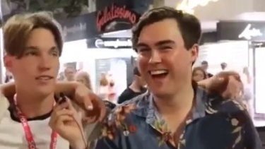 Gold Coast Young LNP chair Barclay McGain (right) laughs along with a racist slur by a "schoolie", Jake Scott (left).