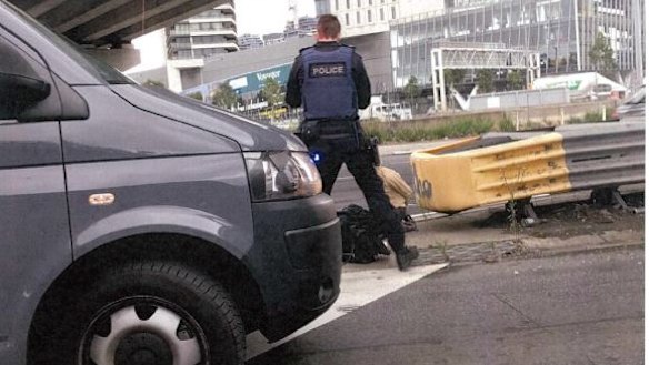 Senior Constable Roland Jones standing with James Gargasoulas' girlfriend Akiir Muo when she got out of his car. Intersection of Montague Street and Westgate Freeway on-ramp. 
