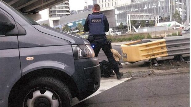 Senior Constable Roland Jones standing with James Gargasoulas' girlfriend Akiir Muo when she got out of his car. Intersection of Montague Street and Westgate Freeway on-ramp. 